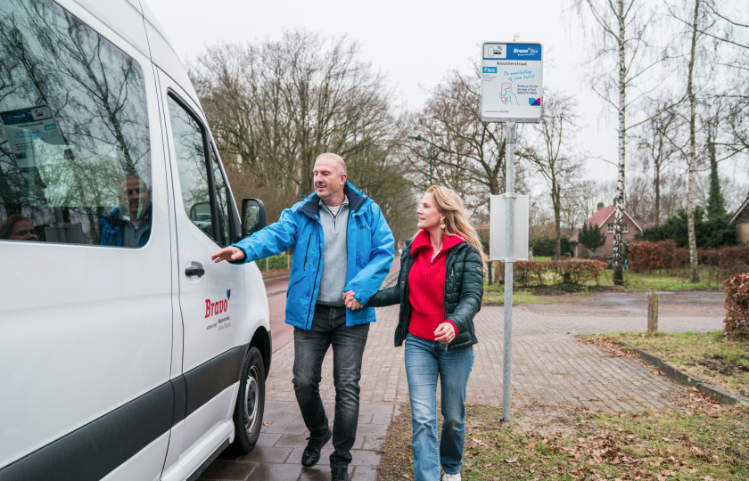 Een bravoflexbusje haalt reizigers op bij een halte