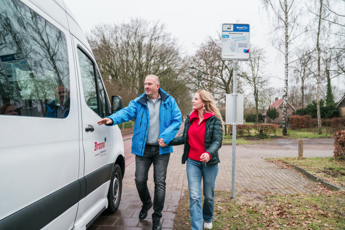 Een bravoflexbusje haalt reizigers op bij een halte